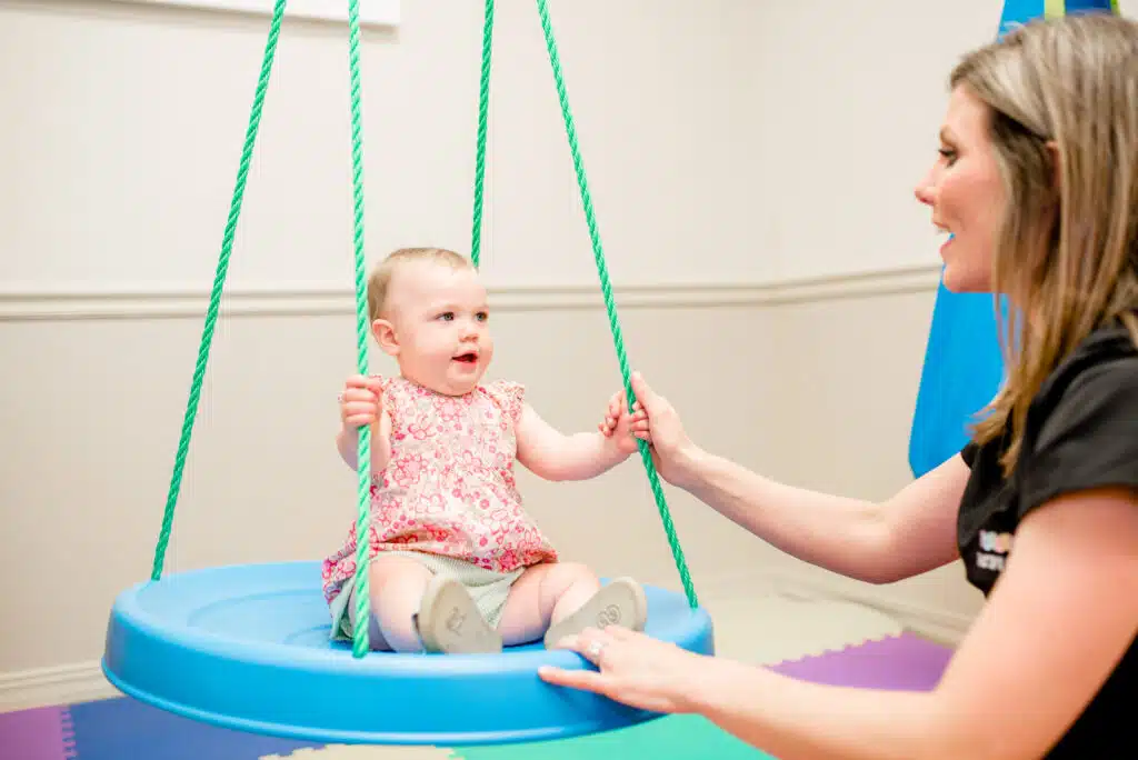 Parent pushing child on a indoor swing