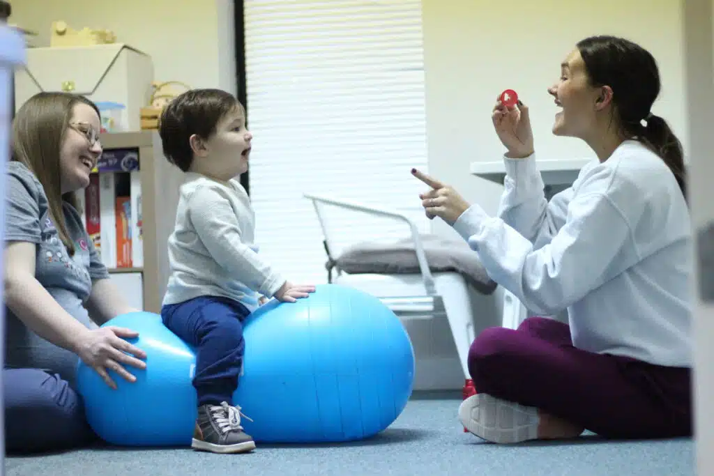 Adult practicing pediatric therapy with two children
